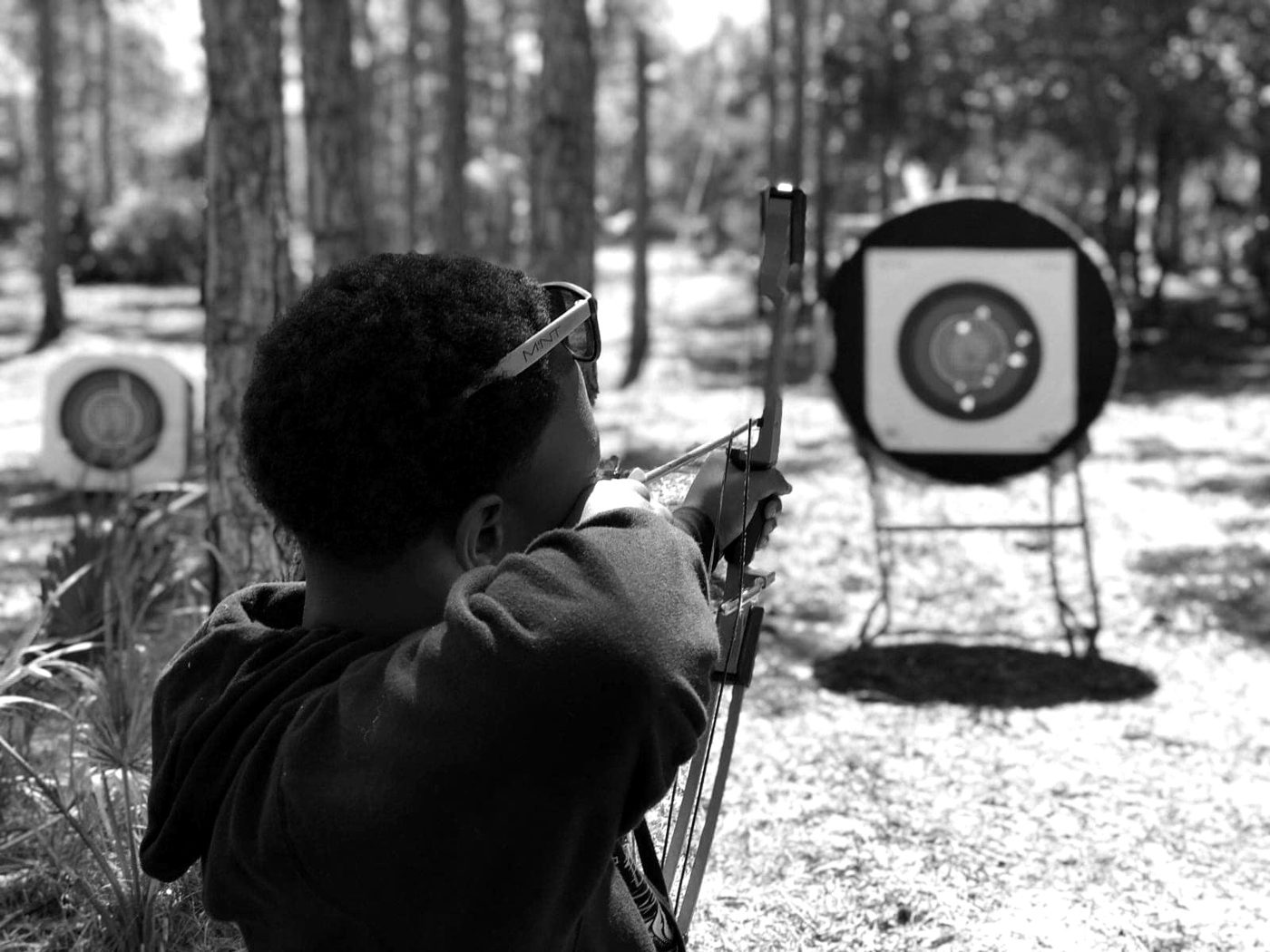 A camper focused on archery at camp.
